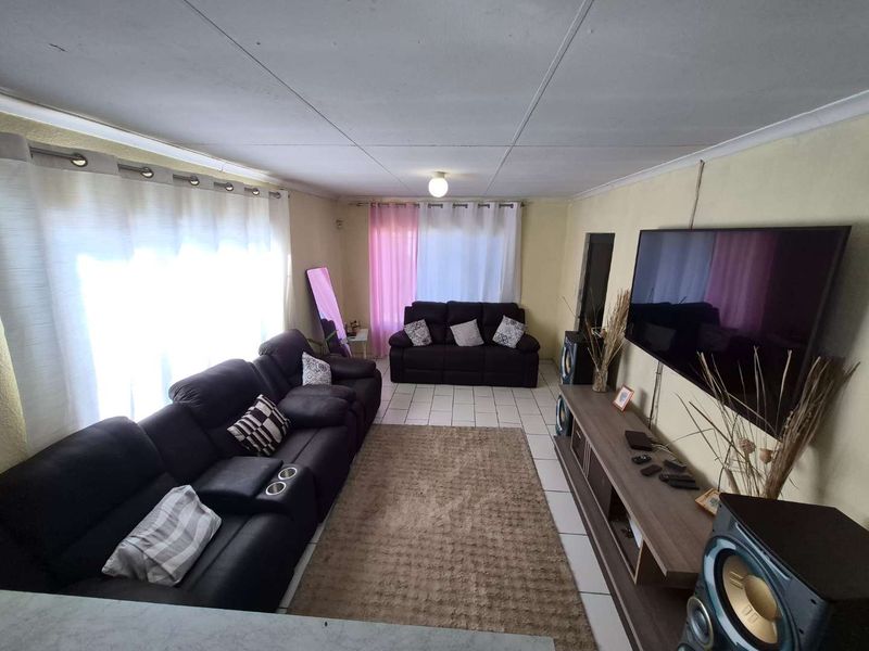 A living room featuring tiled flooring and a coved ceiling, providing a functional space for relaxation.