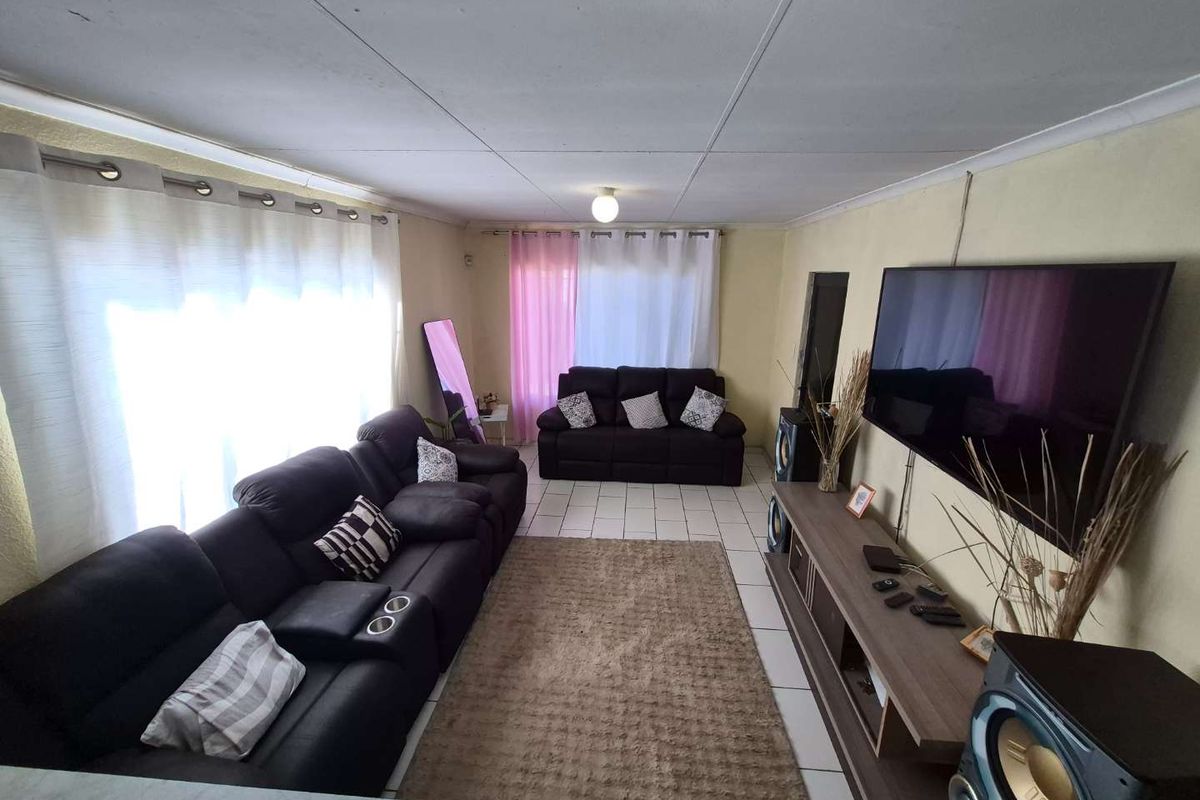 A living room featuring tiled flooring and a coved ceiling, providing a functional space for relaxation.