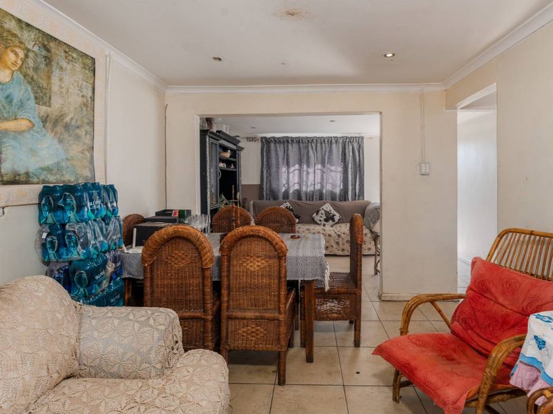 Open plan living and dining area featuring tiled flooring and recessed lighting, offering a functional layout with potential for cosmetic updates.