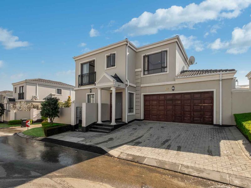 Front elevation of a two-story residential house featuring a paved driveway, double garage, and a covered entrance porch.