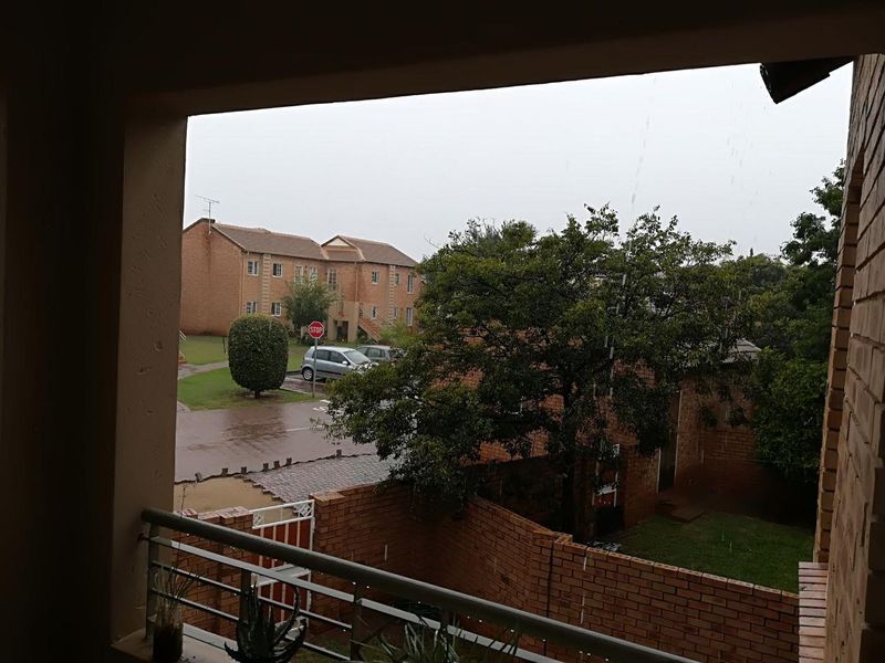 A view from a covered balcony overlooking the complex grounds and surrounding townhouse units.