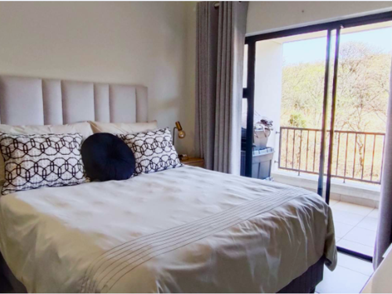 A comfortable bedroom featuring a large sliding glass door that provides natural light and direct access to a private balcony.
