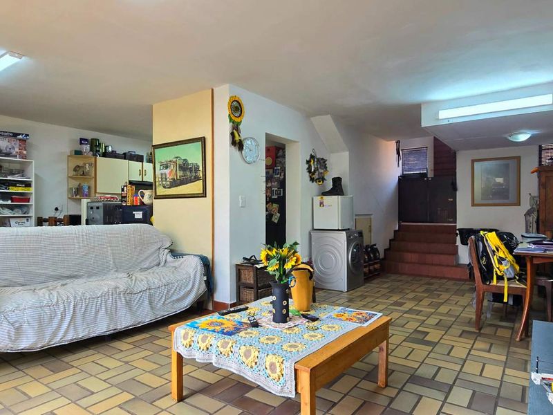 Open plan living area featuring tiled flooring and a staircase leading to the upper level.