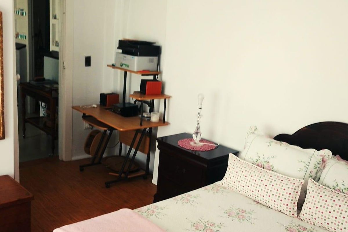 A bedroom featuring laminate flooring and a doorway leading to an adjacent room.