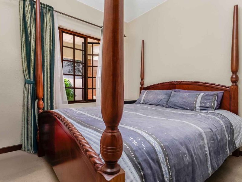 A bedroom featuring a timber-framed window and neutral wall finishes, providing a comfortable and functional sleeping space.