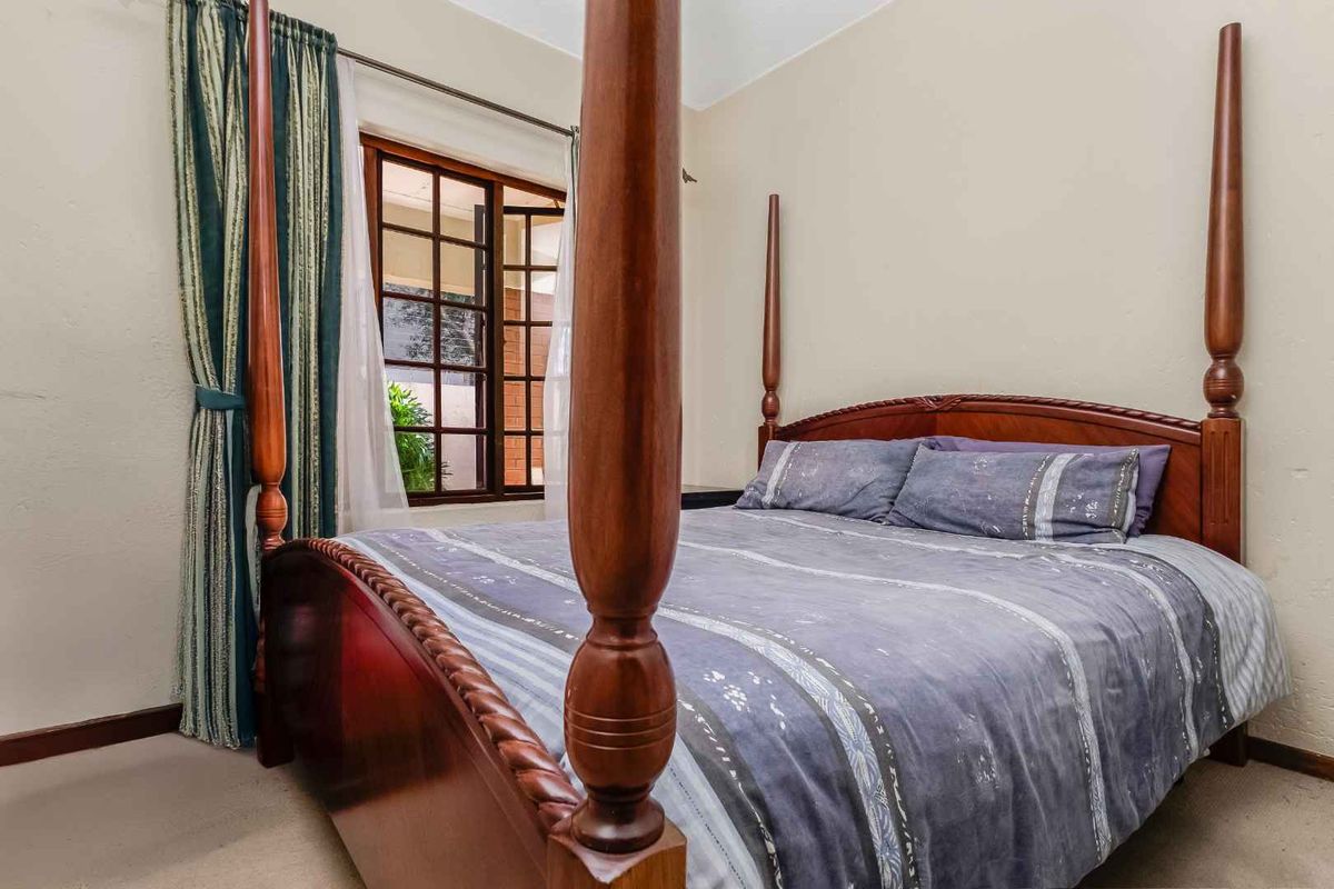 A bedroom featuring a timber-framed window and neutral wall finishes, providing a comfortable and functional sleeping space.