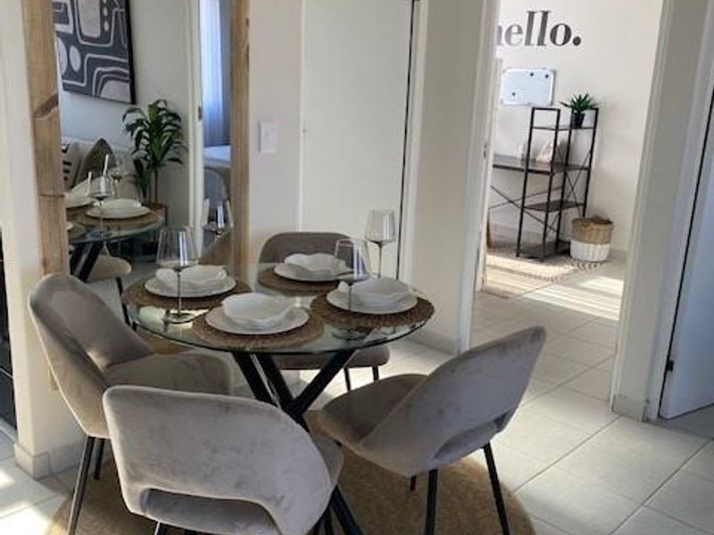 A bright dining area featuring tiled flooring and open access to adjacent rooms, creating a functional and connected living space.
