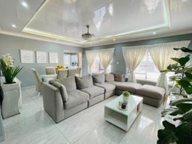 Spacious open-plan living and dining area featuring modern tiled flooring, a recessed ceiling with integrated lighting, and large windows allowing ample natural light.