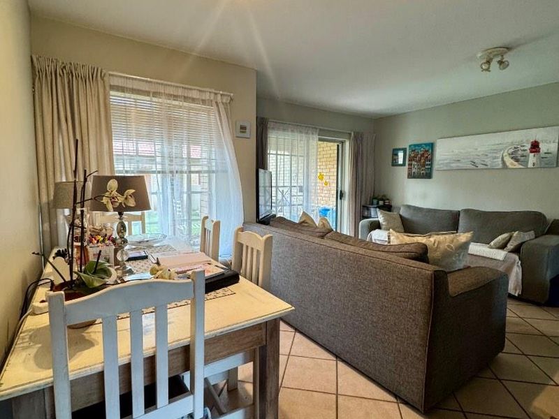 Open plan living and dining area featuring ceramic tile flooring and sliding glass doors leading to an outdoor patio space.