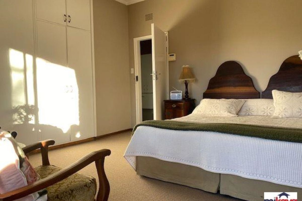 A bedroom featuring built-in cupboards and carpeted flooring, offering a functional and comfortable living space.