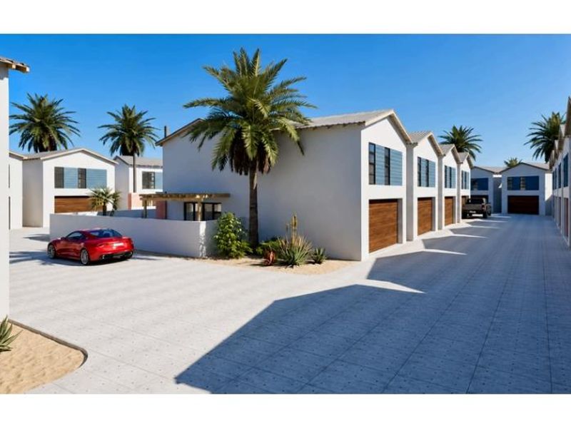 A modern townhouse complex featuring a paved driveway, multiple garage access points, and clean architectural lines in a well-maintained estate setting.