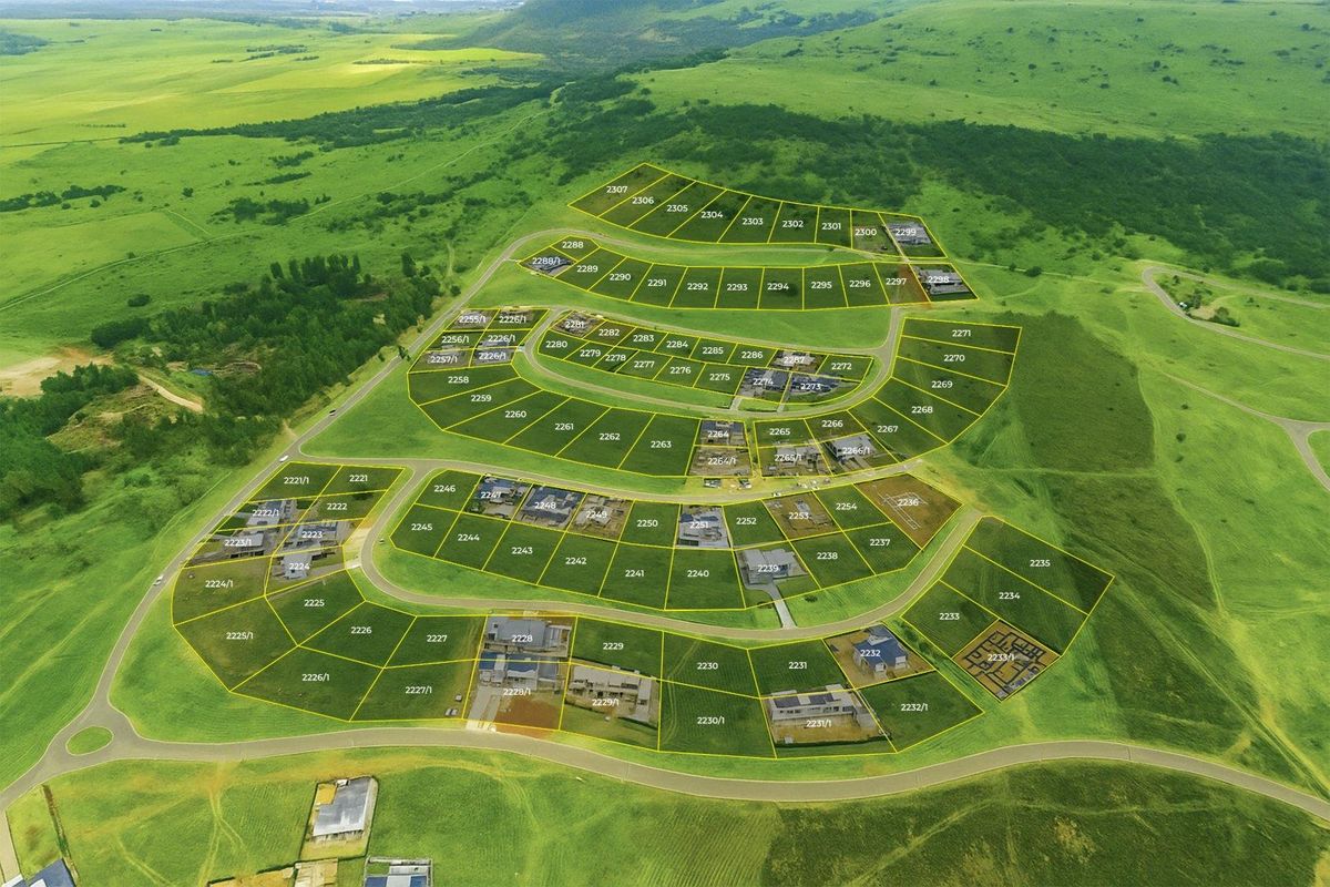 Aerial view of a residential estate development showing subdivided land parcels, road infrastructure, and surrounding green landscape.
