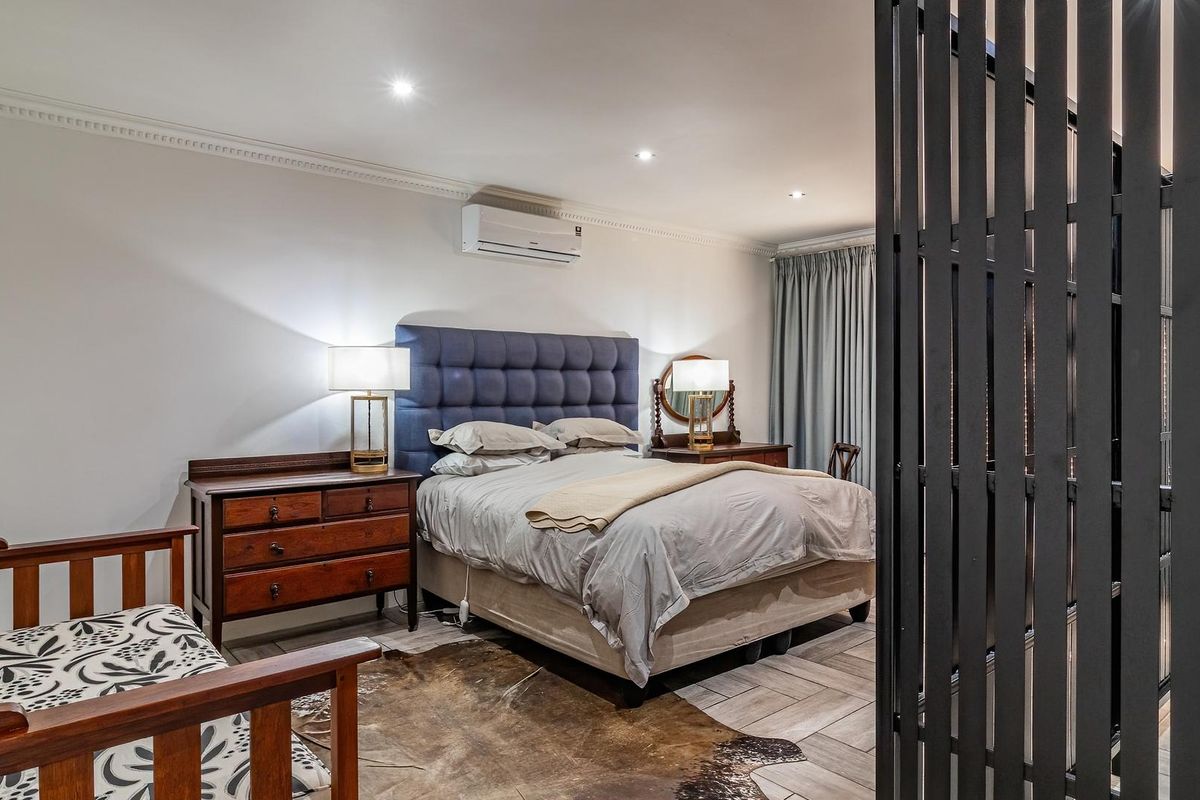 A well-maintained bedroom featuring tiled flooring, crown molding, recessed lighting, and a wall-mounted split-system air conditioner.