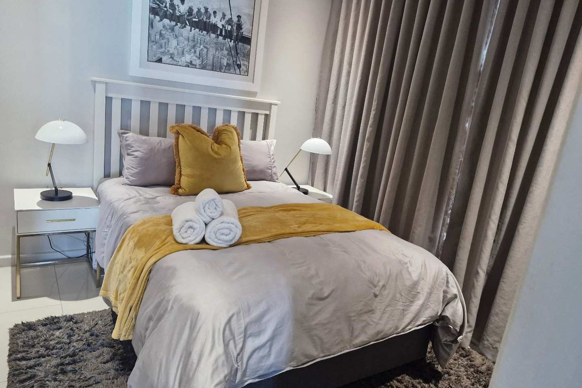 A well-maintained bedroom featuring neutral tones, floor-to-ceiling curtains, and tiled flooring.