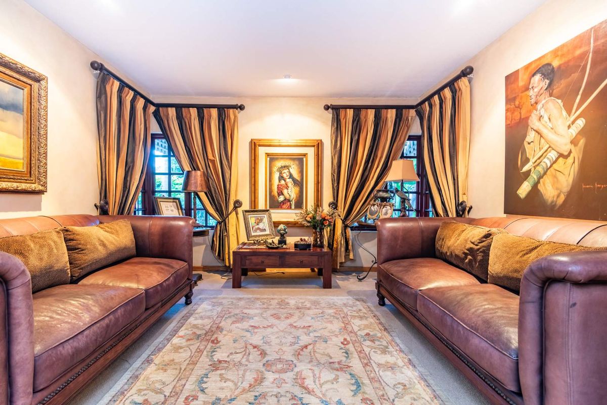 A formal living room featuring symmetrical window placement with curtain rods and neutral wall finishes.