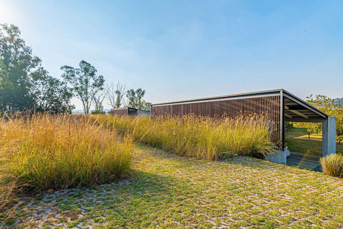 Modern architectural structure featuring timber slat screening and integrated landscaping, showcasing a contemporary design approach with natural textures.