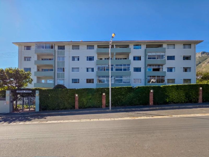Front elevation of Breda Park apartment complex featuring multi-story residential units with private balconies and secure gated street access.