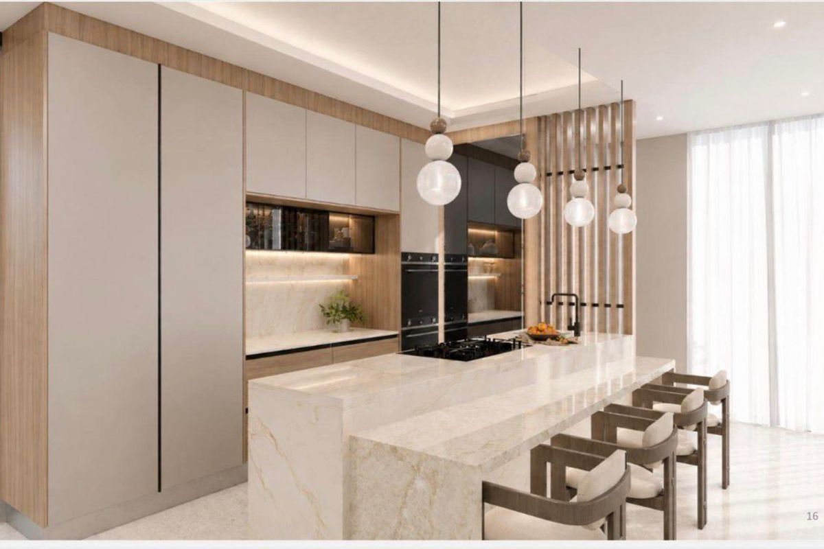 Modern kitchen featuring a large stone island, integrated cabinetry, built-in ovens, and elegant pendant lighting in a contemporary open-plan layout.
