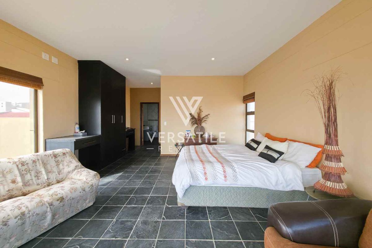 Spacious bedroom featuring dark slate tile flooring, recessed ceiling lighting, and built-in cabinetry.