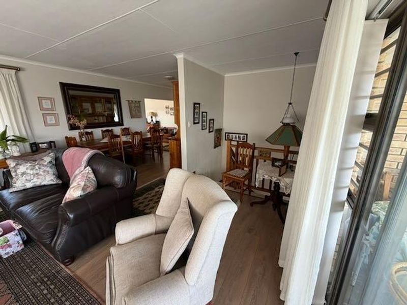 Open plan living and dining area featuring laminate flooring and large sliding glass doors providing natural light and access to the exterior.