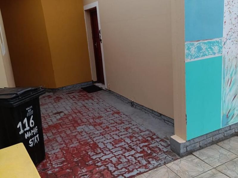 A rear courtyard area featuring painted paving and exterior walls with visible signs of wear and weathering.