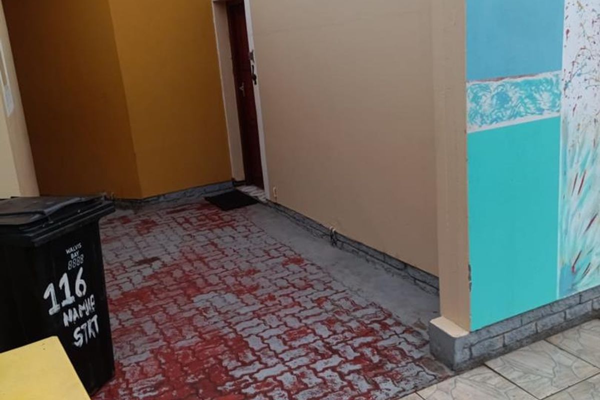 A rear courtyard area featuring painted paving and exterior walls with visible signs of wear and weathering.
