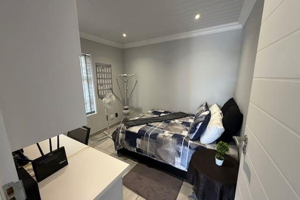 A compact bedroom featuring tiled flooring, recessed downlighting, and a tongue and groove ceiling finish.