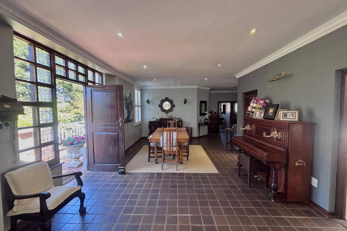 Spacious living area featuring tiled flooring, crown molding, recessed lighting, and large leaded glass windows providing access to the outdoor patio.