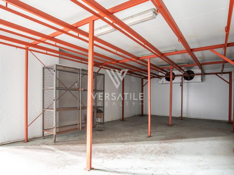 Industrial utility space featuring heavy-duty steel framing, integrated refrigeration cooling units, and durable concrete flooring, suitable for storage or specialized industrial operations.