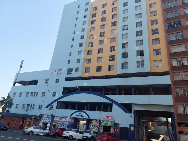 Exterior view of the Bay View apartment building featuring a multi-story facade with ground-level retail spaces and integrated parking.