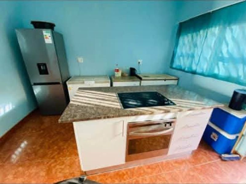 A functional kitchen area featuring a central island with a built-in oven, cooktop, and granite countertops, providing a practical workspace.