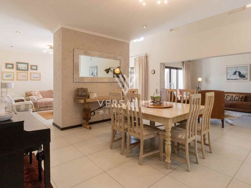 Spacious open-plan living and dining area featuring neutral tiled flooring and recessed lighting, offering a versatile layout for modern family living.