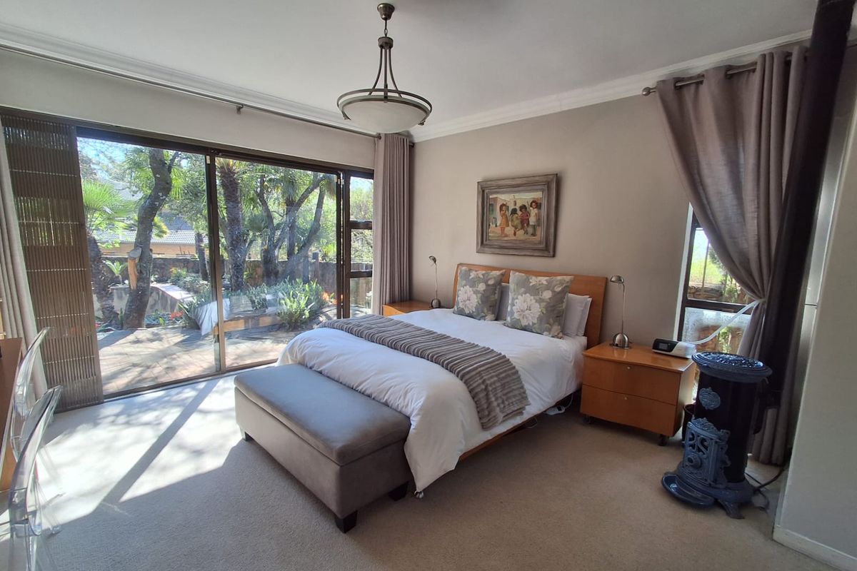 Spacious bedroom featuring large sliding glass doors that provide ample natural light and direct access to the garden area.