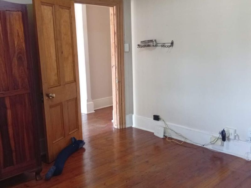 A bedroom featuring original timber flooring, traditional timber door frames, and skirting boards, requiring minor cosmetic updates to the walls and electrical finishes.