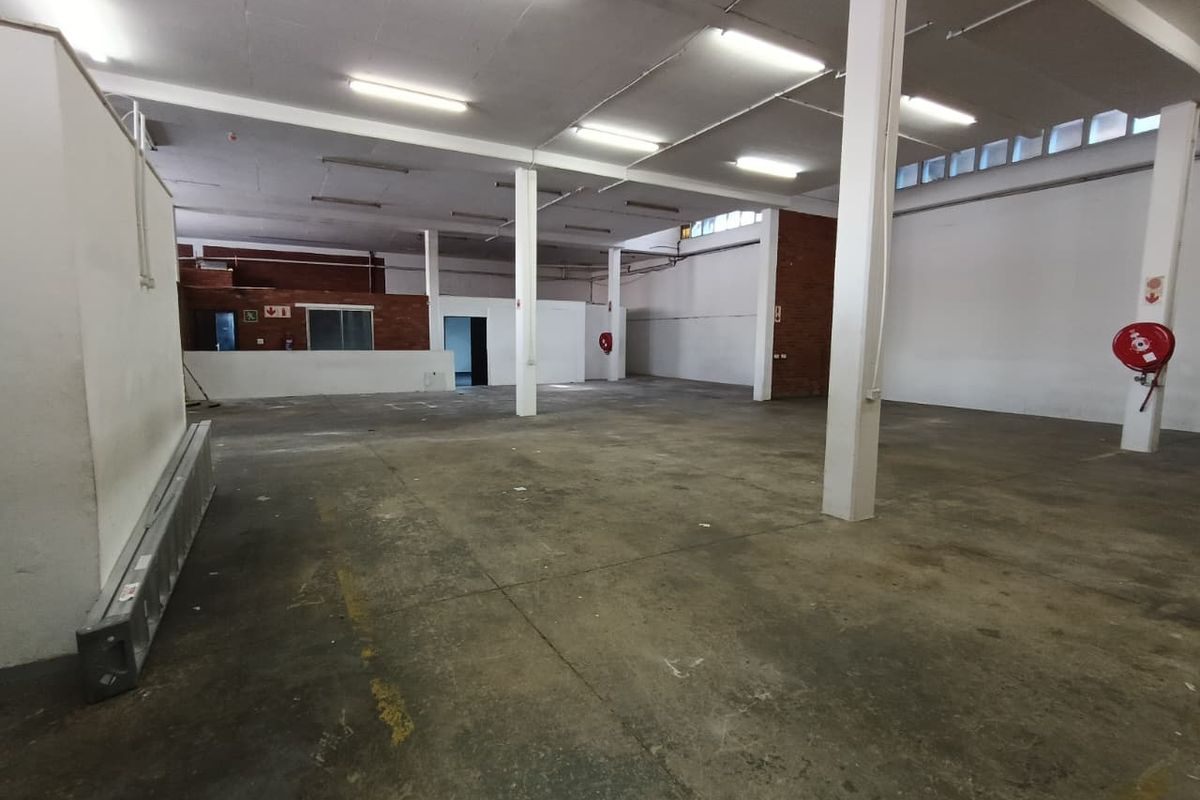 Spacious industrial warehouse unit featuring open-plan floor space, exposed structural columns, and functional overhead lighting, suitable for various commercial or storage applications.
