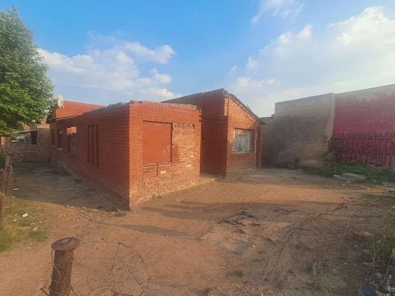 A dilapidated single-story face brick house requiring significant structural repairs, including roof replacement and general exterior renovation.