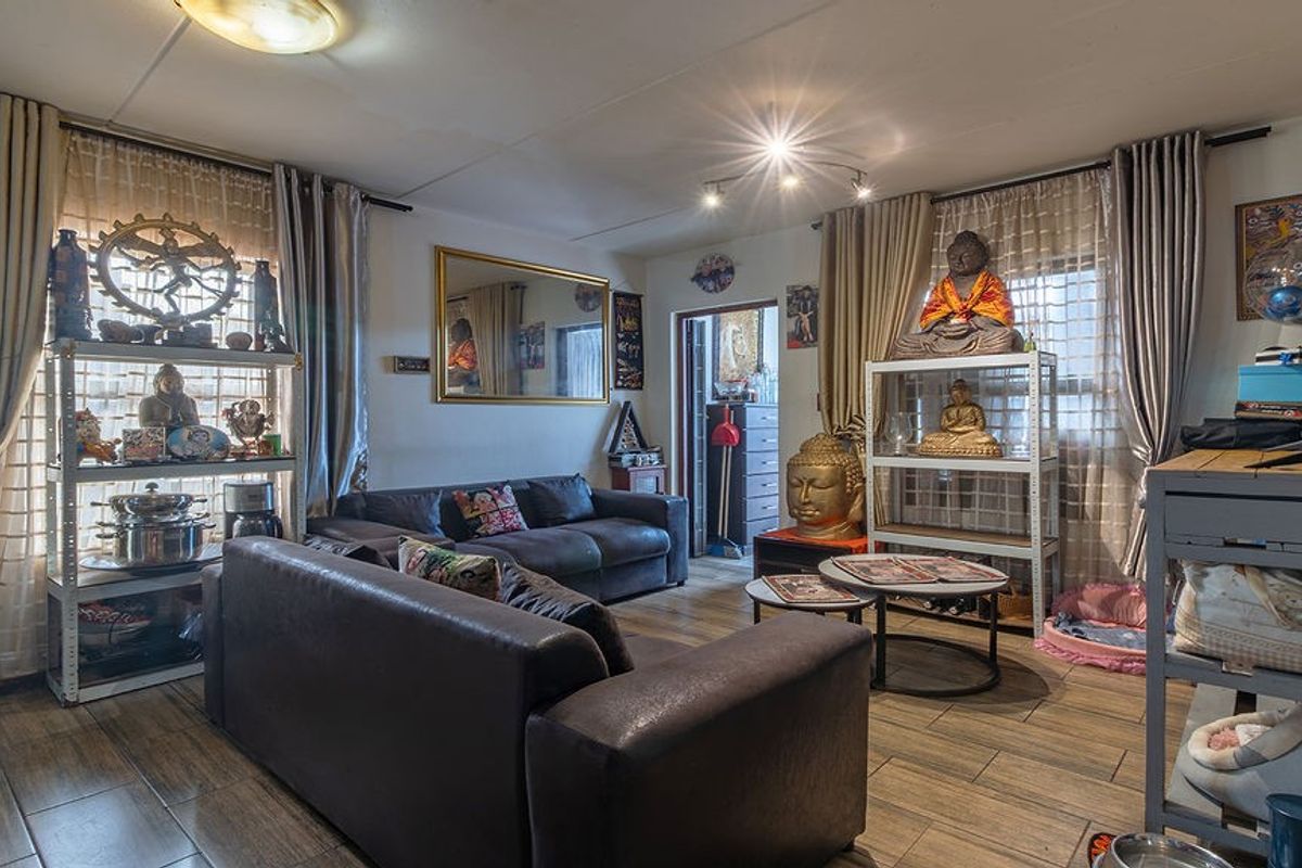 A living room featuring wood-look tile flooring and dual ceiling lighting fixtures, providing a functional space for relaxation.
