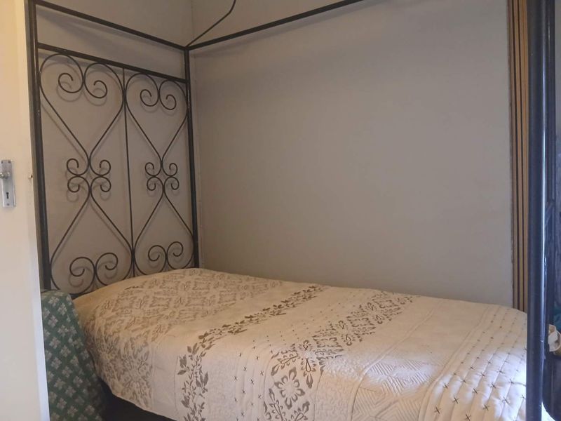 A bedroom interior featuring neutral wall finishes and standard architectural elements.