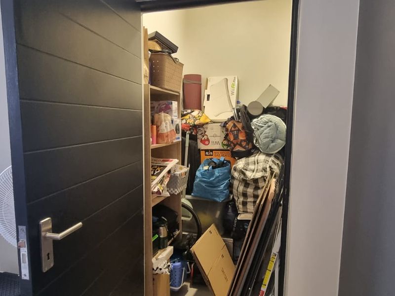 A small utility or storage closet accessed via a modern dark-finished internal door.