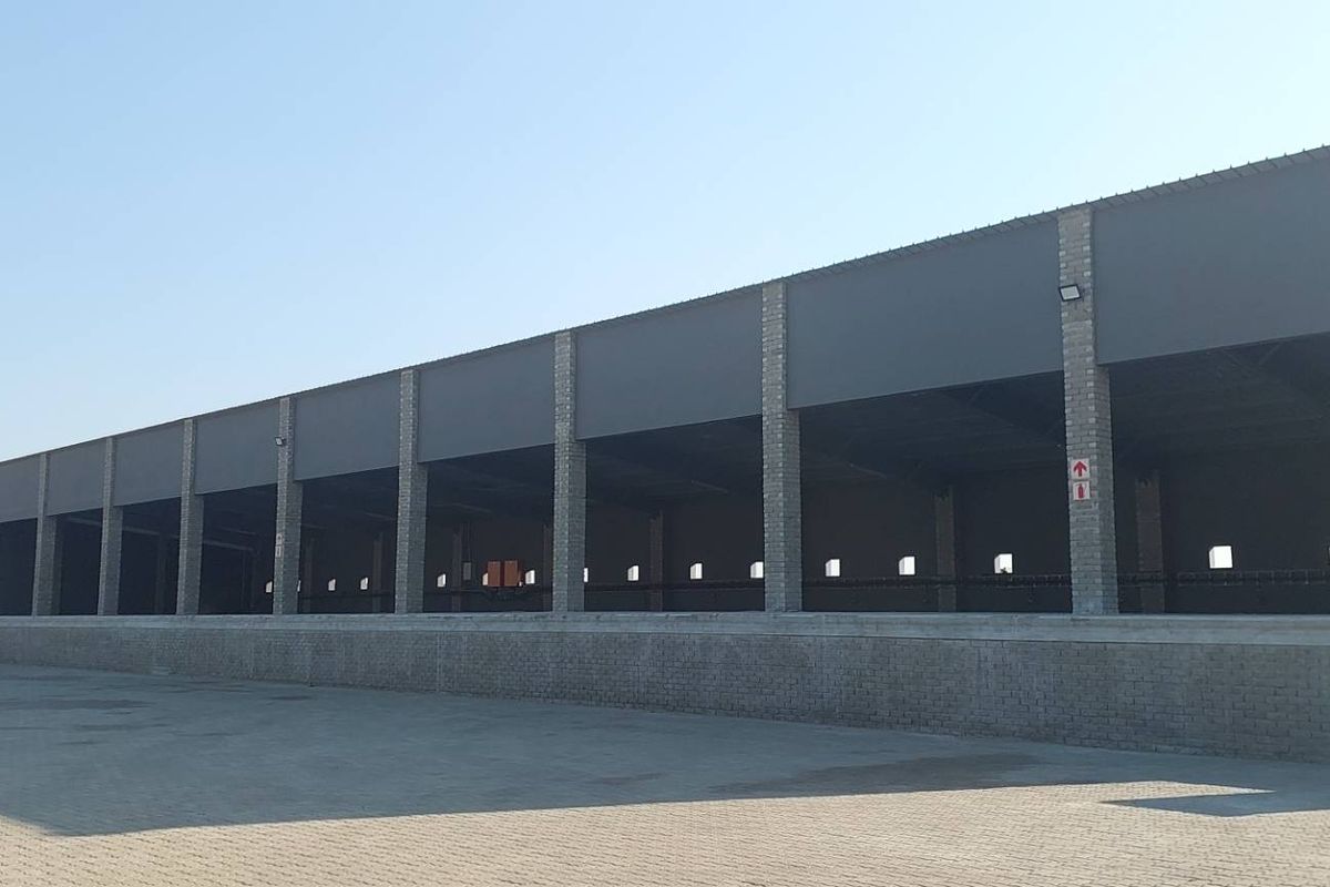 Large industrial warehouse facility featuring an expansive paved yard, raised loading dock, and open-plan structural design suitable for logistics or manufacturing operations.