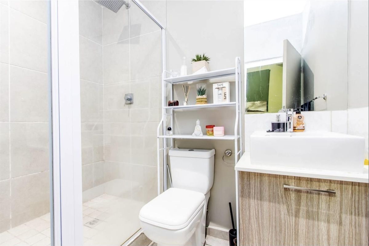 Modern bathroom featuring a glass-enclosed shower, a contemporary vanity with a basin, and a standard toilet.