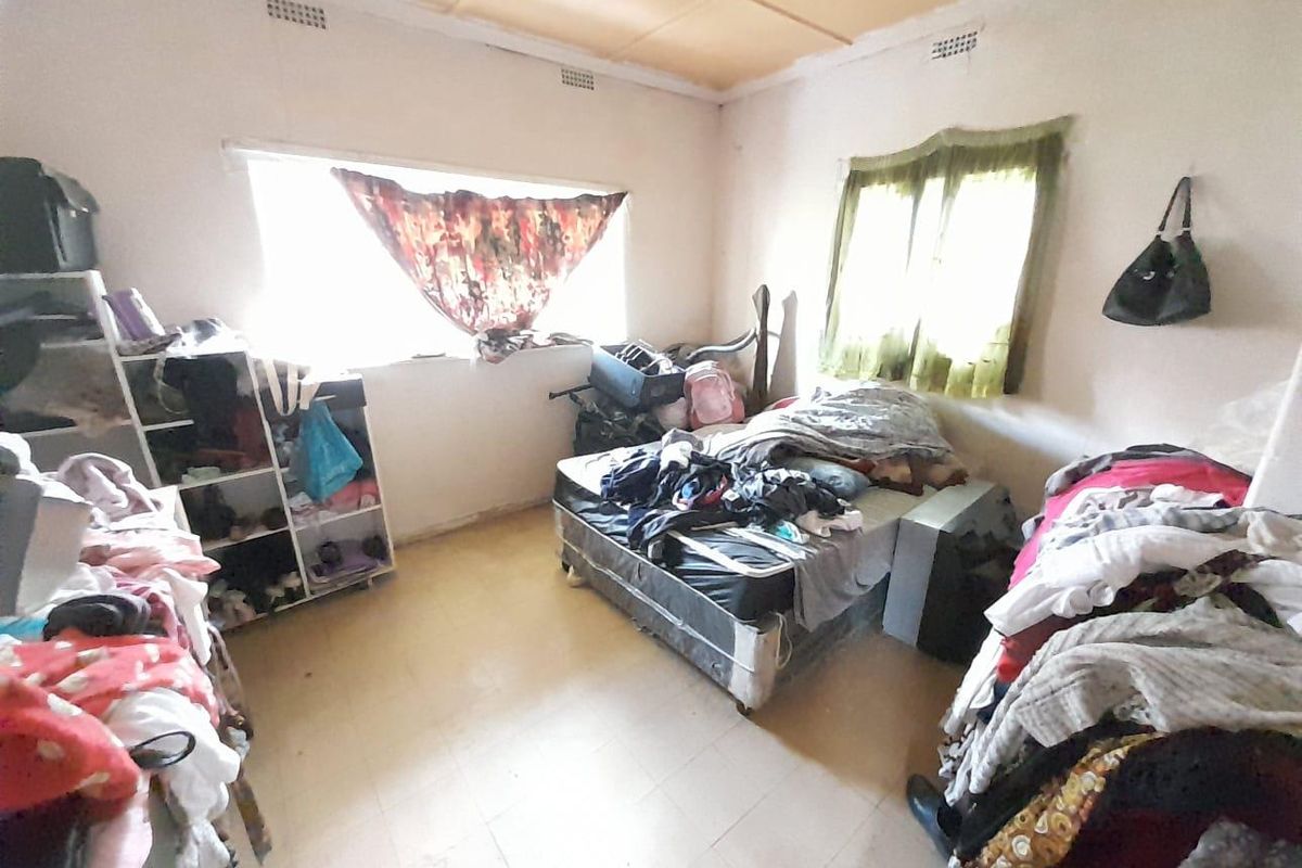 A bedroom featuring tiled flooring and standard window fixtures, requiring cosmetic updates to enhance its appeal.