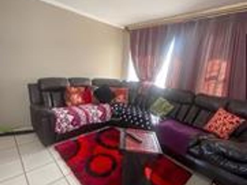 A living room area featuring tiled flooring and neutral wall finishes, providing a functional space for relaxation.