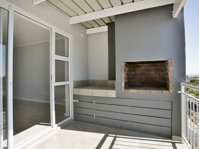 Covered balcony featuring a built-in brick braai, tiled flooring, and sliding door access to the interior living space.