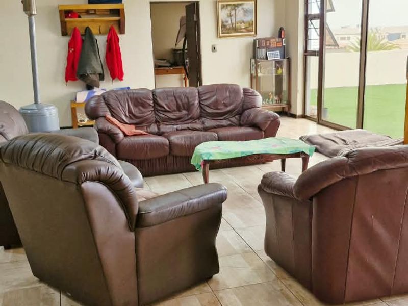 Spacious living room featuring tiled flooring, recessed lighting, and large sliding glass doors providing access to the outdoor area.