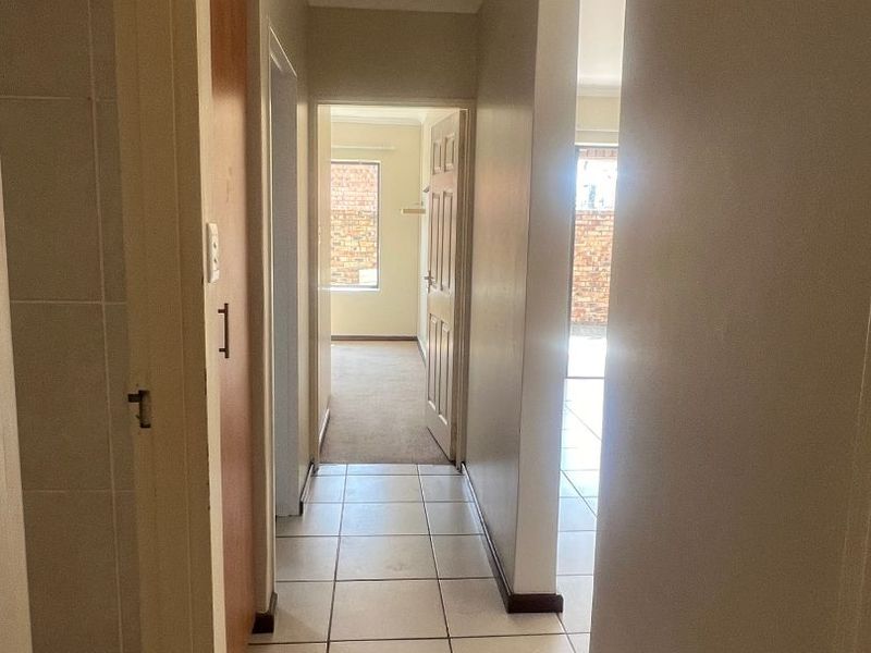 A functional hallway featuring tiled flooring and neutral wall finishes, providing access to adjacent rooms within the apartment.