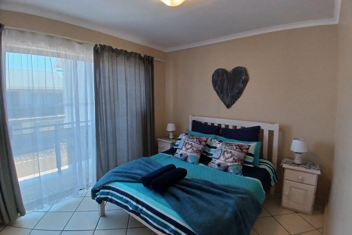 A bedroom featuring tiled flooring and a sliding glass door providing access to an outdoor balcony area.