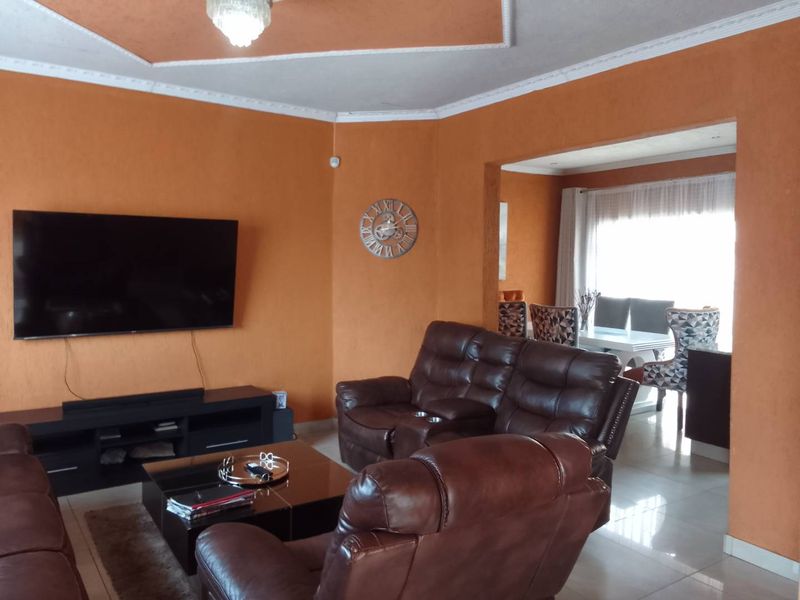 Open plan living and dining area featuring tiled flooring, decorative ceiling coving, and a recessed ceiling feature.