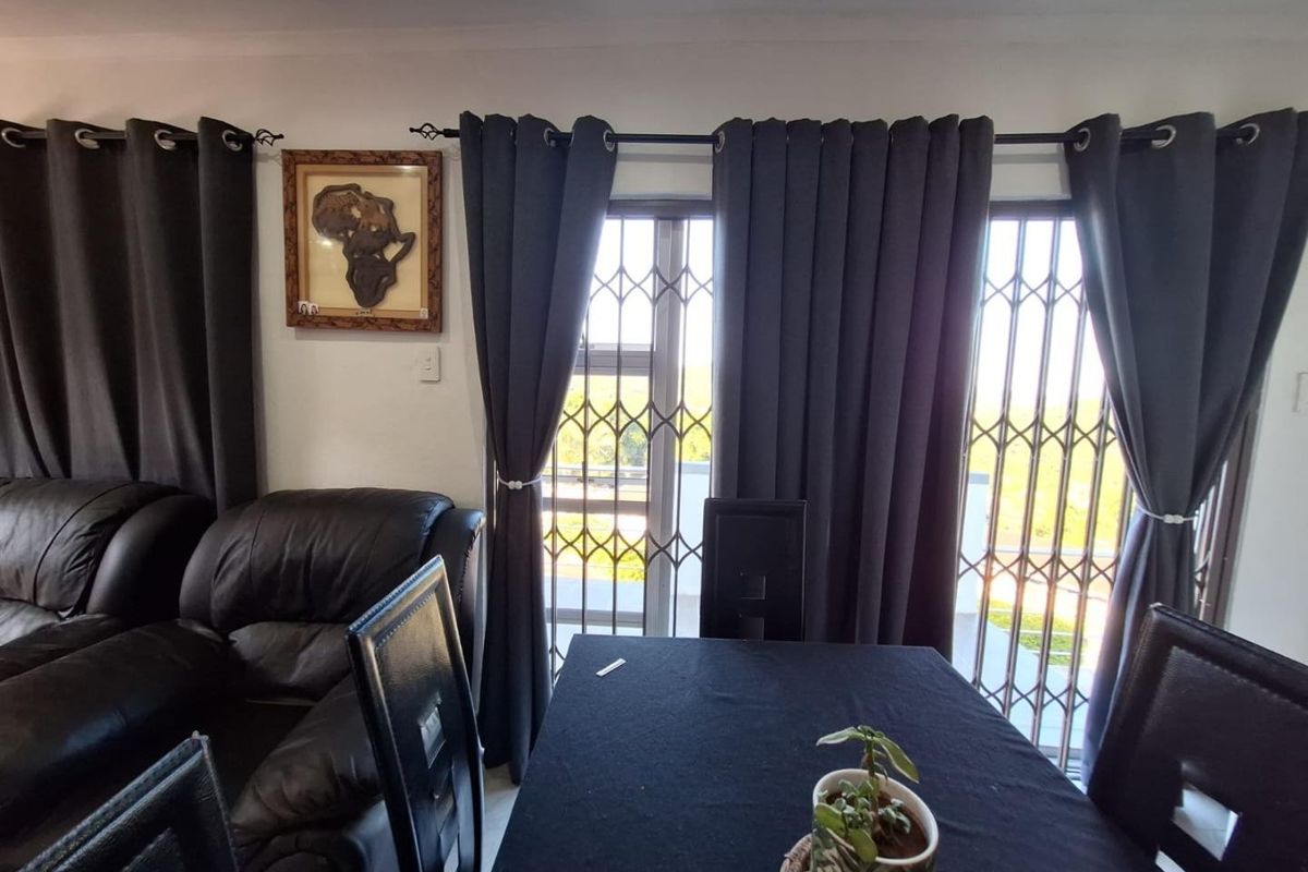 Living area featuring sliding doors with fitted security gates, providing access to the exterior and allowing natural light into the space.