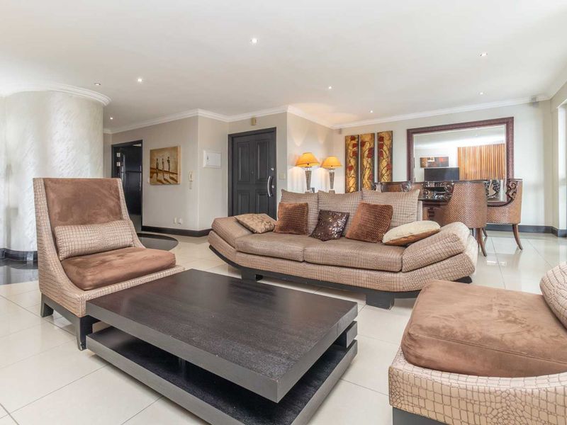 Spacious living area featuring polished tiled flooring, recessed downlighting, and large sliding glass doors providing natural light.